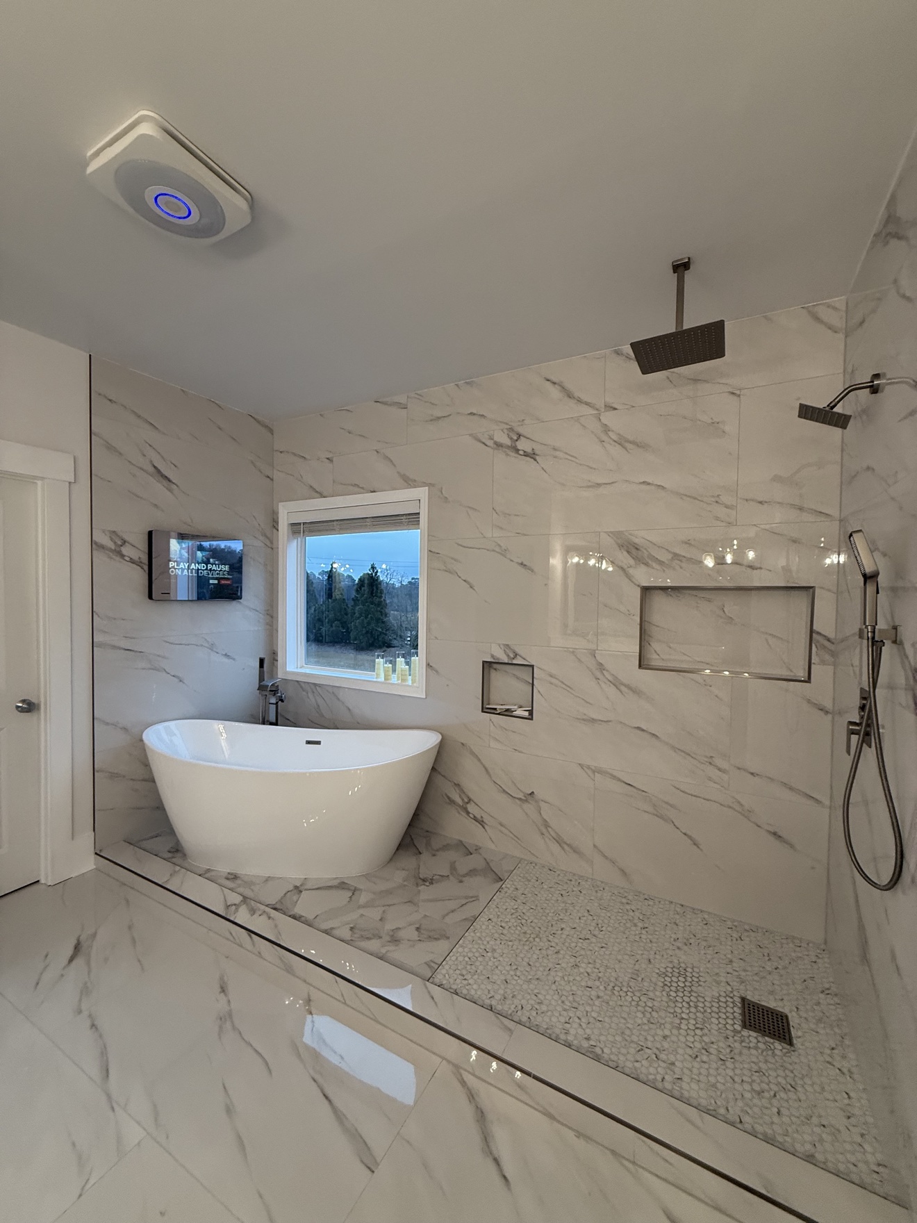 Master bathroom with a freestanding tub and marble tile throughout