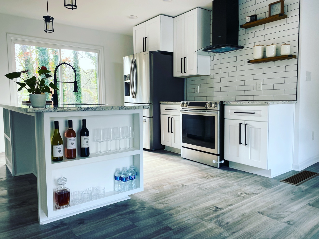 White kitchen with painted cabinets, subway tile and an island with open shelving